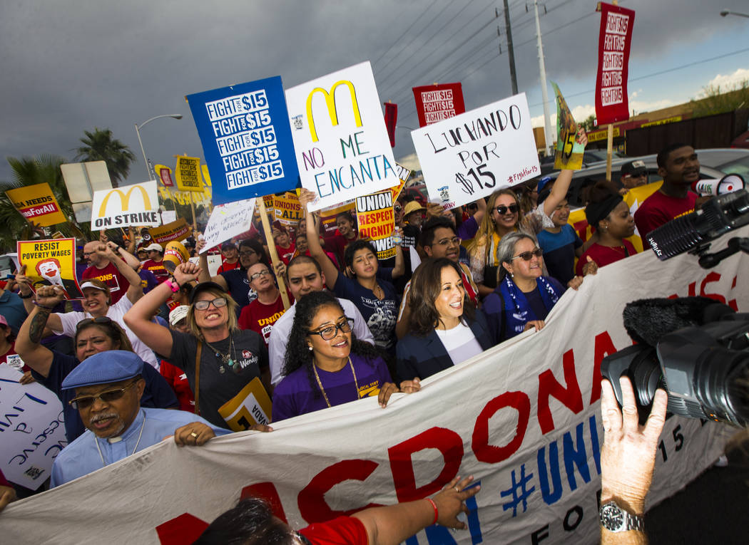 U.S. Sen. Kamala Harris, D-Calif., a Democratic presidential hopeful, center right, joins worke ...