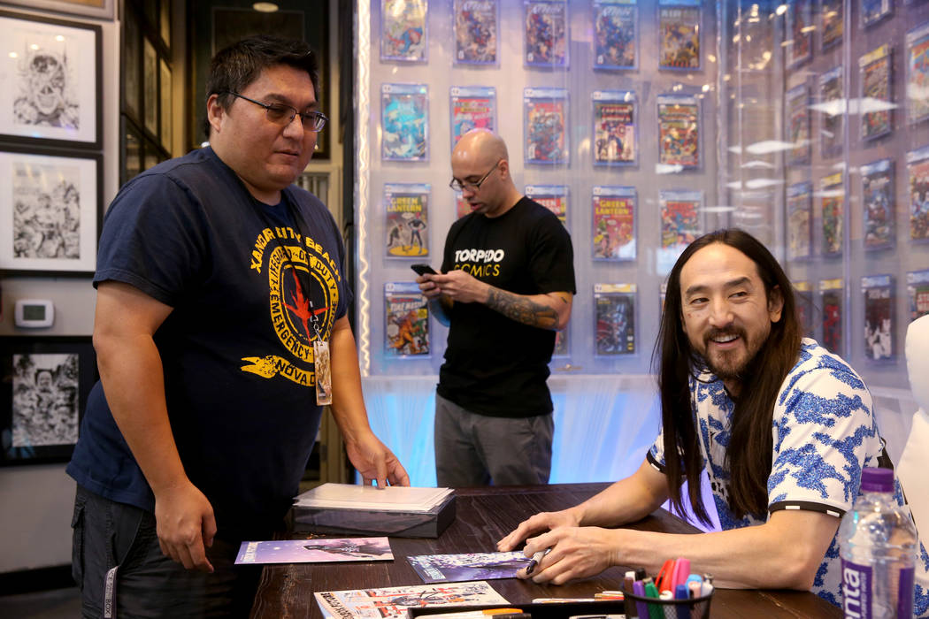 DJ Steve Aoki, right, visits with Larry Nakauchi of Las Vegas during a signing for his new comi ...