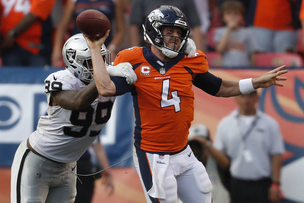 Denver Broncos quarterback Case Keenum (4) is pressured by Oakland Raiders defensive end Arden ...