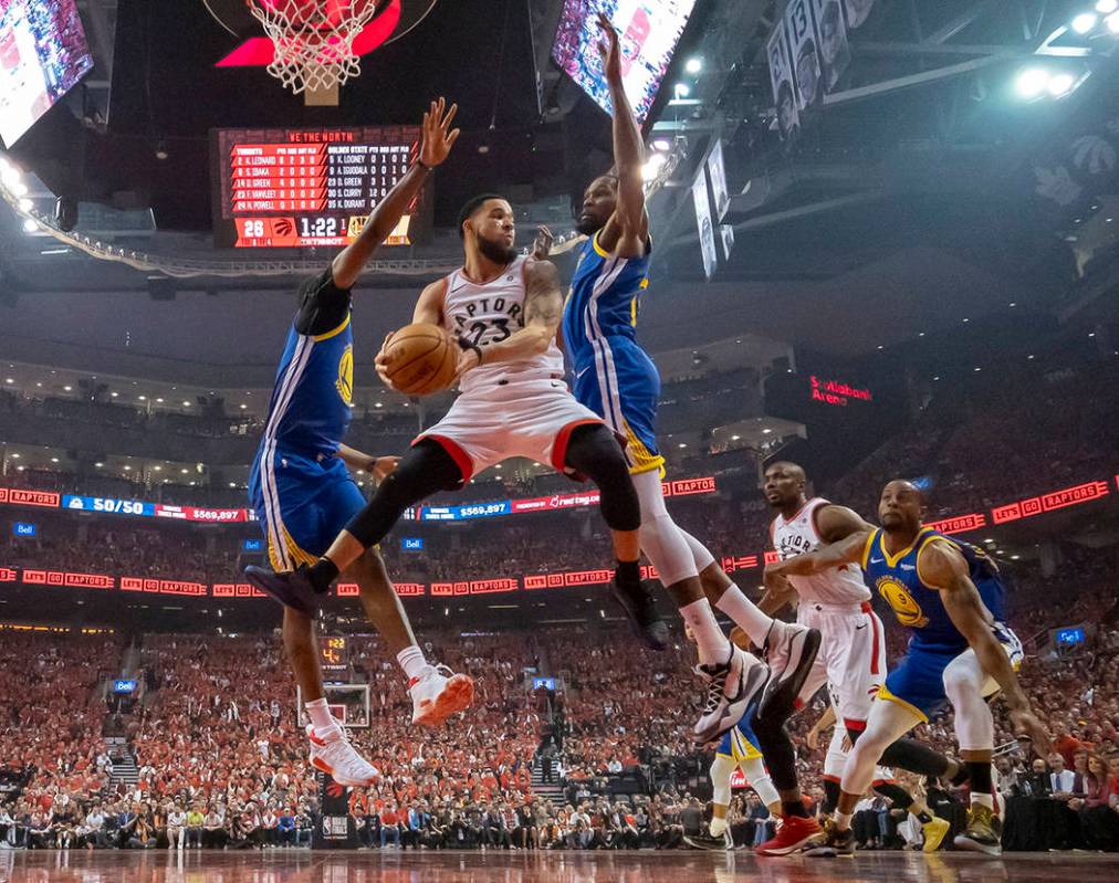 Toronto Raptors guard Fred VanVleet (23) grabs a rebound under pressure from Golden State Warri ...