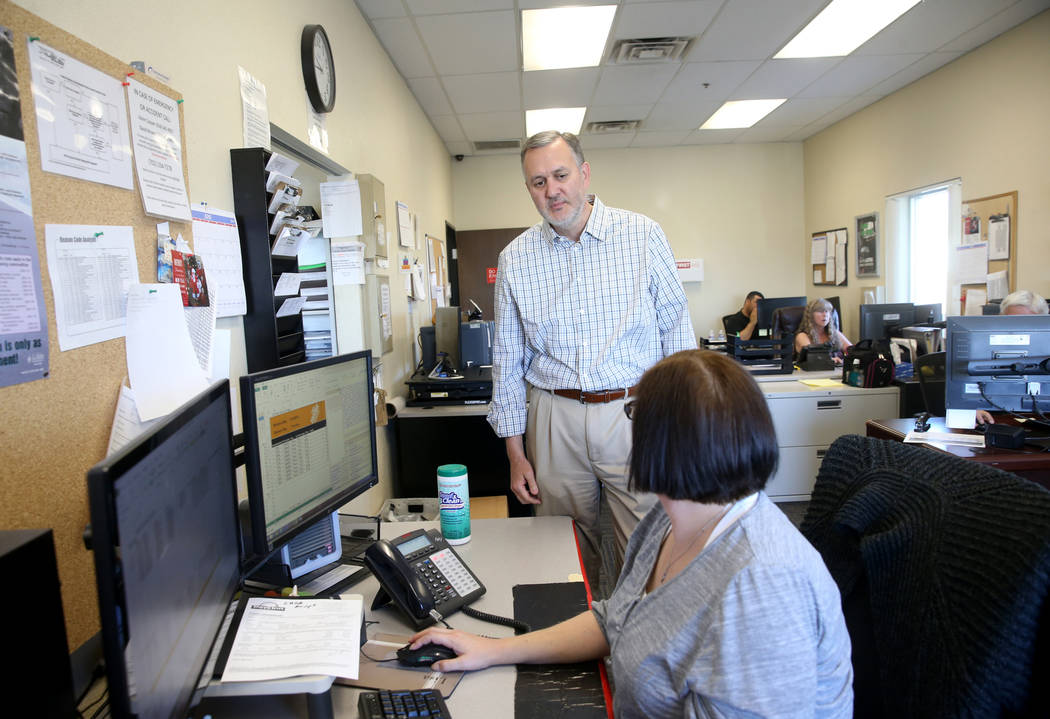 Paul Truman, owner of Truline Corporation, talks to Lisa Hill, driver manager, at his trucking ...