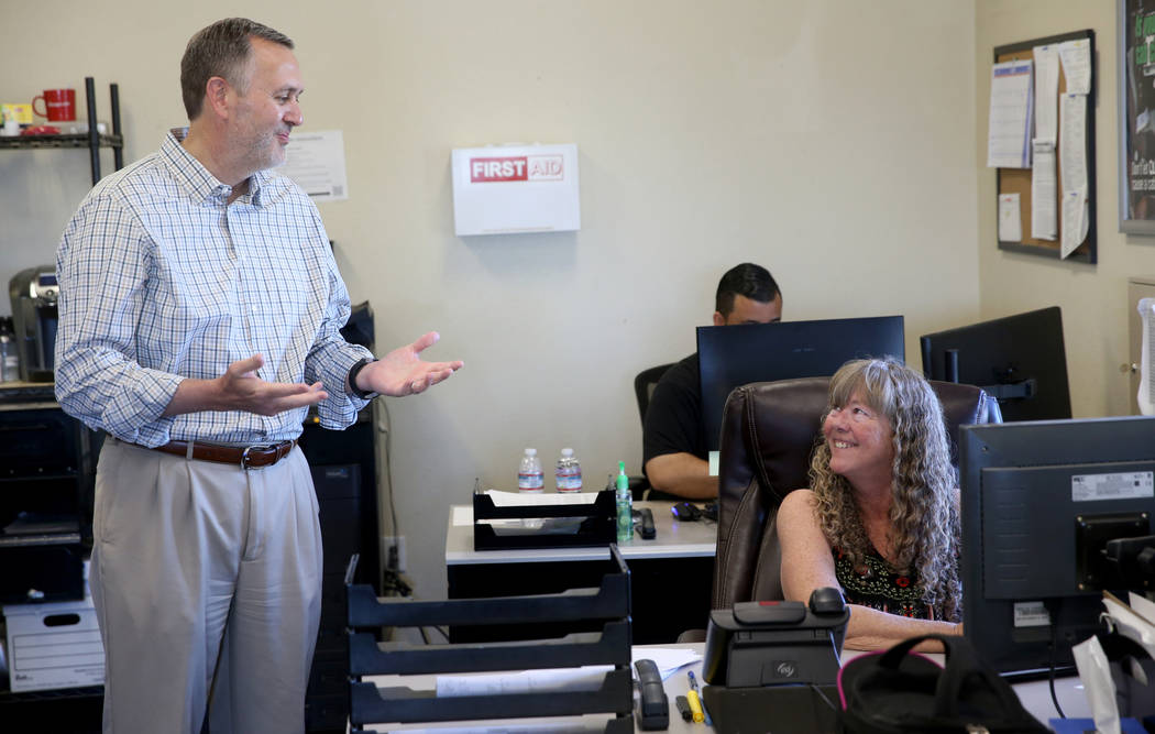 Paul Truman, owner of Truline Corporation, talks to Pam Mrgan, fleet manager, at his trucking c ...