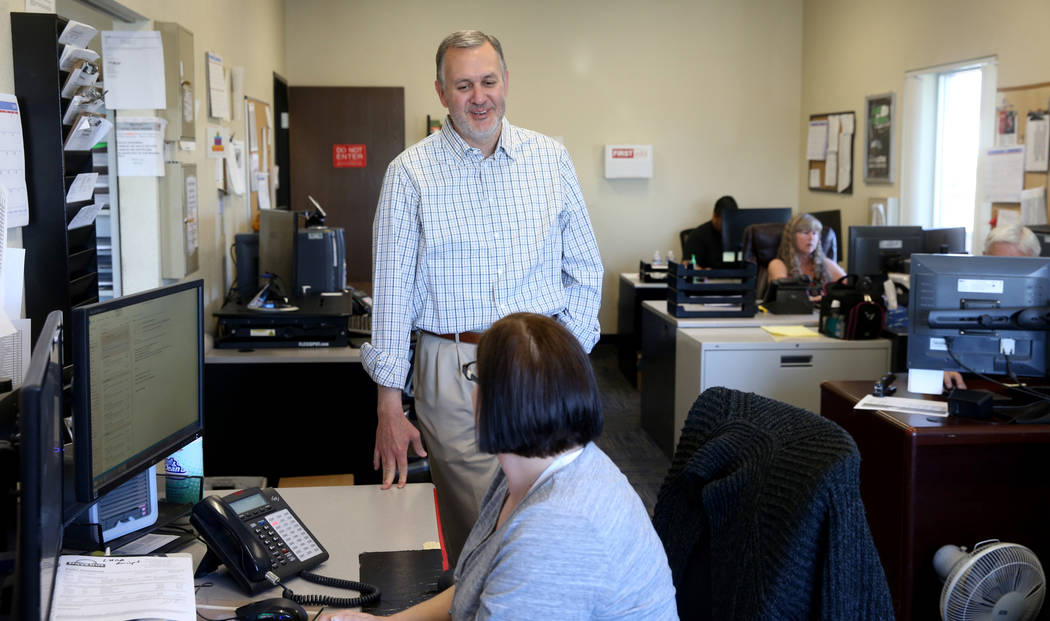 Paul Truman, owner of Truline Corporation, talks to Lisa Hill, driver manager, at his trucking ...