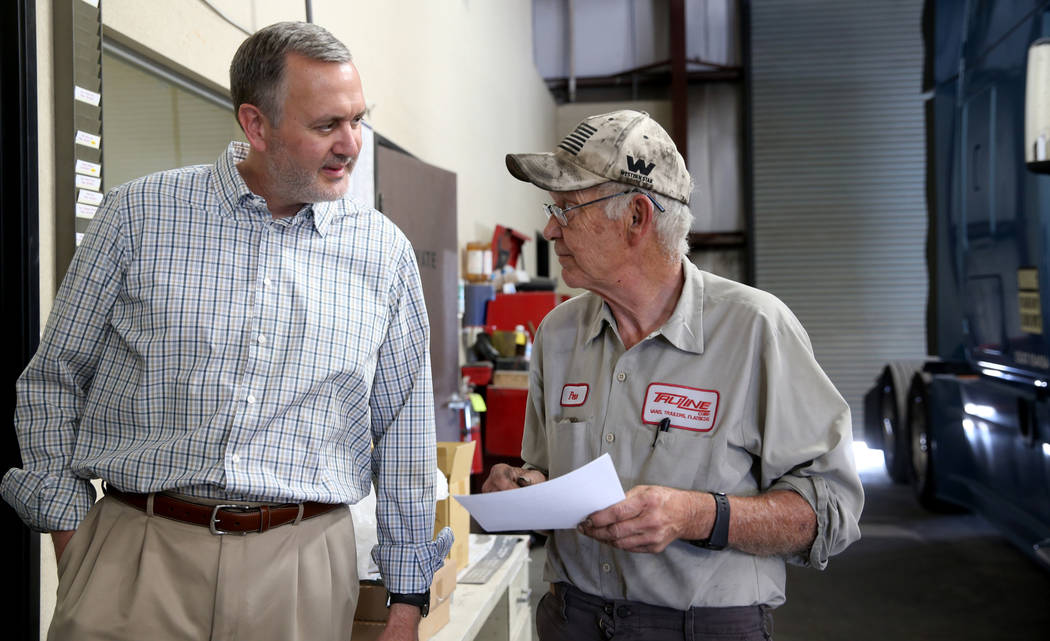 Paul Truman, owner of Truline Corporation, talks to mechanic Pete Schladweiler at his trucking ...