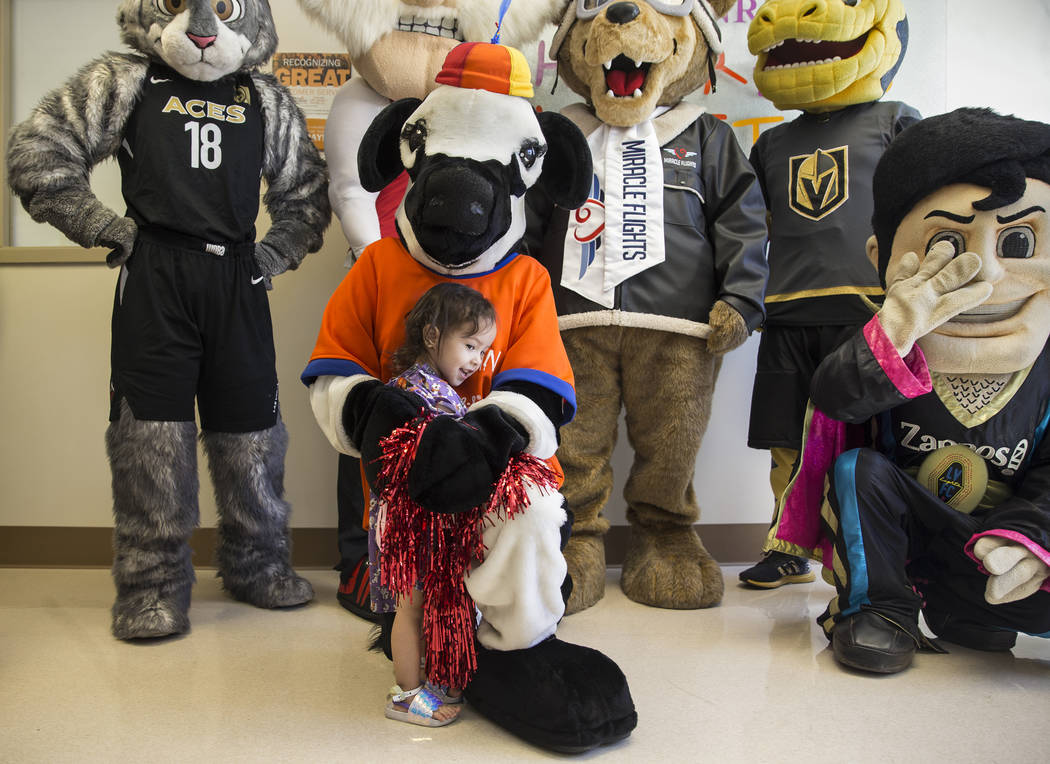 Camila Silva, 2, hugs the Chick-fil-A Cow during a welcome event for Miles the Miracle Flights ...