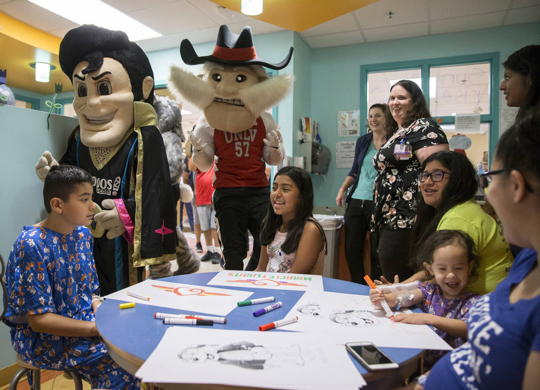 Joshua Gallardo, left, 11, Jazlin Martinez, 11, and Camila Silva, 2, are greeted by LV Lights F ...