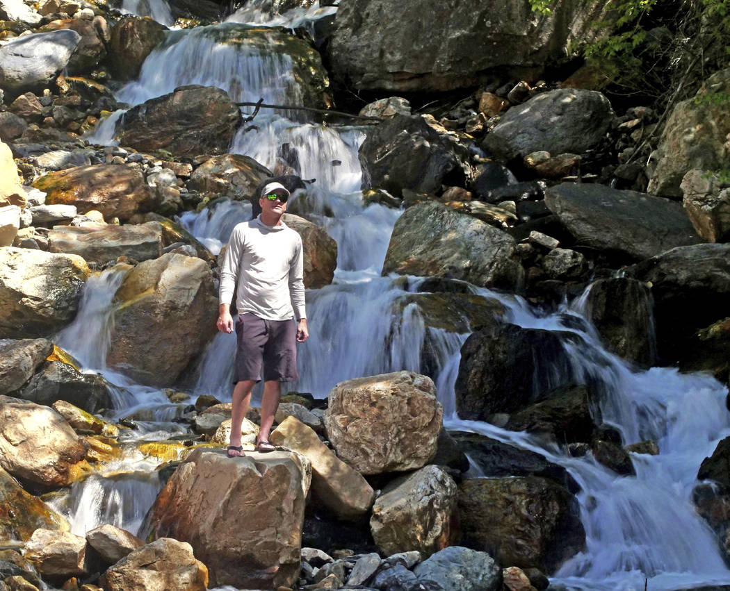 This Monday, June 10, 2019, photo shows hiker Tony Larsen posing for a photograph at a waterfal ...