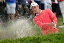 Justin Rose, of England, hits out of the bunker on the 15th hole during the first round of the ...