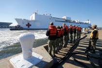 FILE - In this Dec. 18, 2018 file photo, line handlers wait as the US Navy Hospital Ship USNS C ...