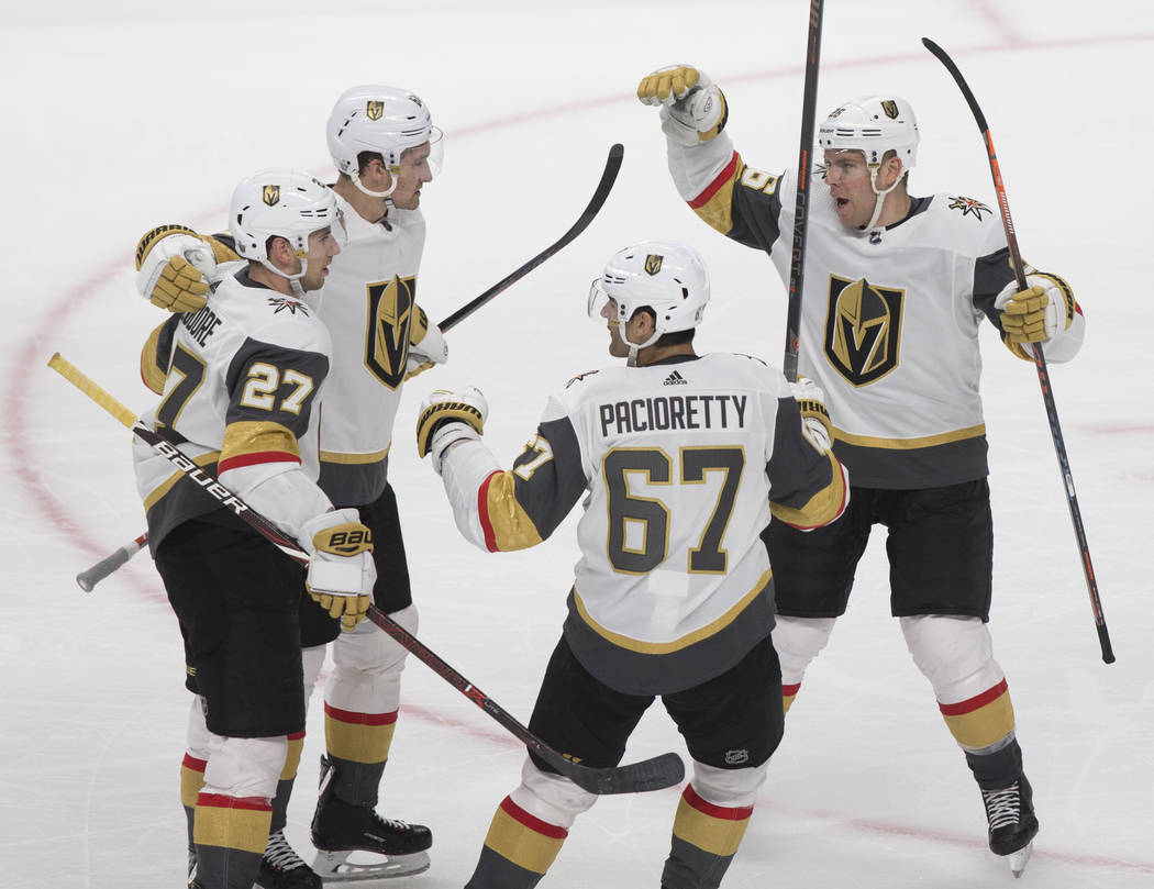 Golden Knights right wing Mark Stone (61), top/left, celebrates his third-period goal with team ...