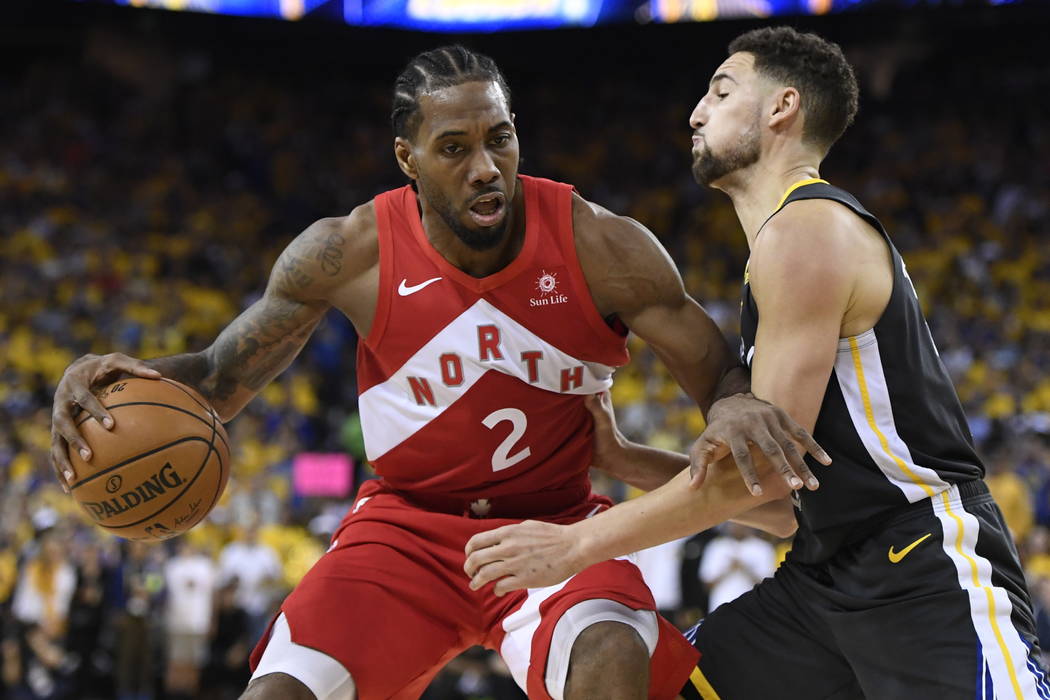 Toronto Raptors forward Kawhi Leonard (2) handles the ball while Golden State Warriors guard Kl ...