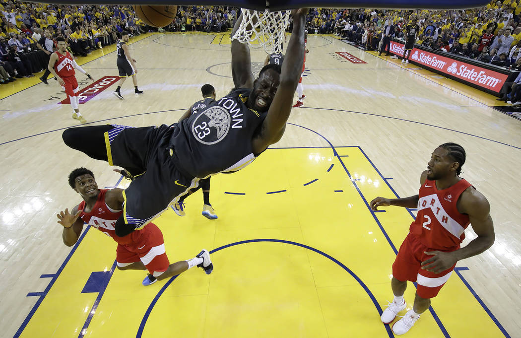 Golden State Warriors forward Draymond Green (23) dunks over Toronto Raptors guard Kyle Lowry, ...
