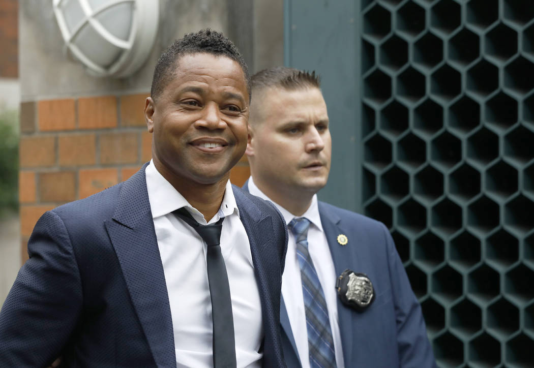 Actor Cuba Gooding Jr., left, is lead by a police officer from New York's Special Victim's Unit ...