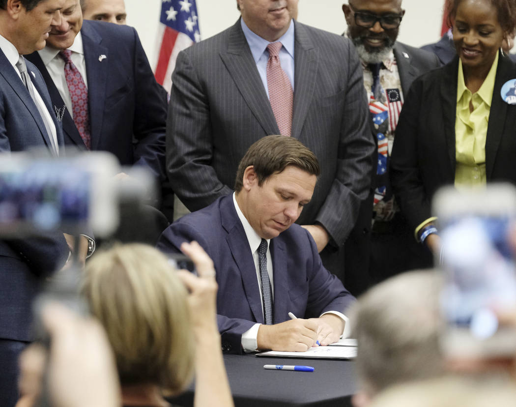 Florida Gov. Ron DeSantis signs the Sanctuary City bill Friday, June 14, 2019 at the Okaloosa C ...