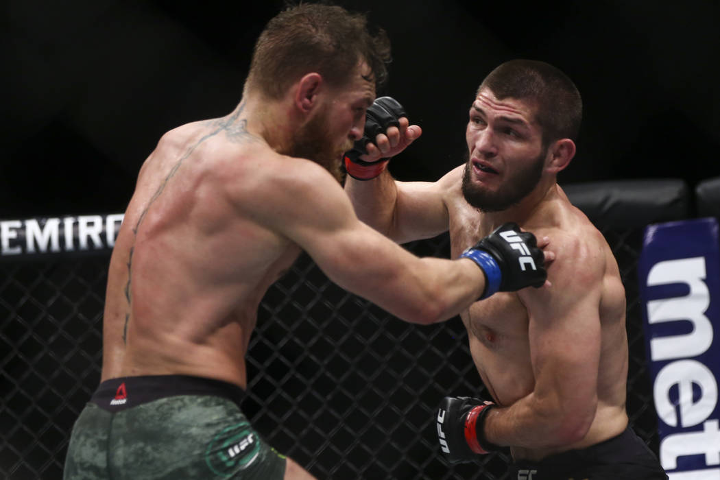 Conor McGregor, left, fights Khabib Nurmagomedov during their lightweight title bout at UFC 229 ...