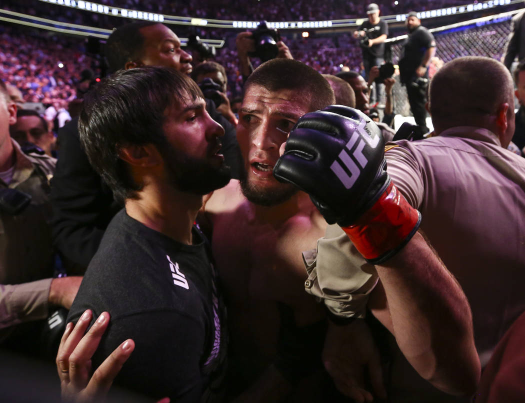 Khabib Nurmagomedov is restrained outside of the octagon after he defeated Conor McGregor at UF ...