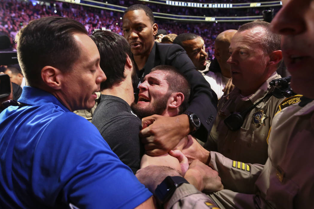 Khabib Nurmagomedov is restrained outside of the octagon after he defeated Conor McGregor at UF ...