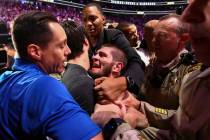 Khabib Nurmagomedov is restrained outside of the octagon after he defeated Conor McGregor at UF ...