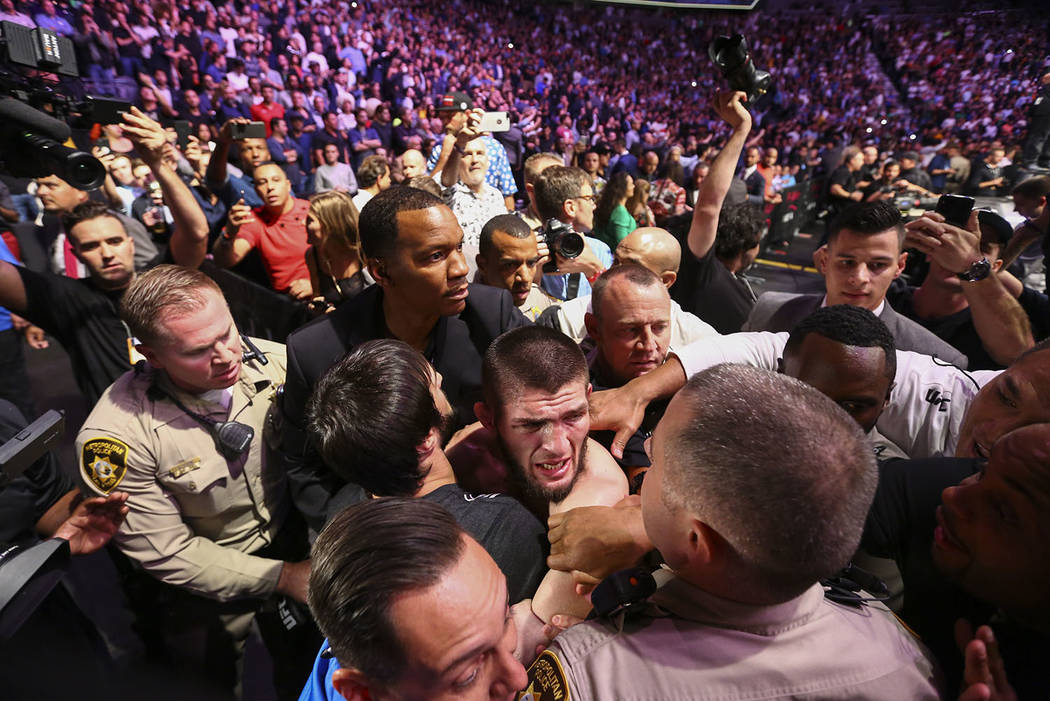 Khabib Nurmagomedov is restrained outside of the octagon after he defeated Conor McGregor at UF ...