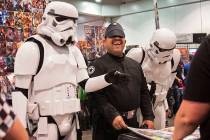 Jathniel Velazquez, center, shares a laugh with a pair of stormtroopers while looking at comic ...