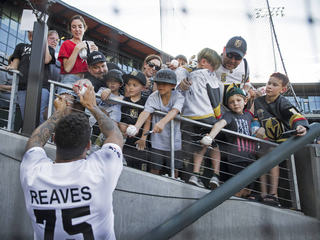 Golden Knights right wing Ryan Reaves, left, signs autographs before the start of the Battle Fo ...