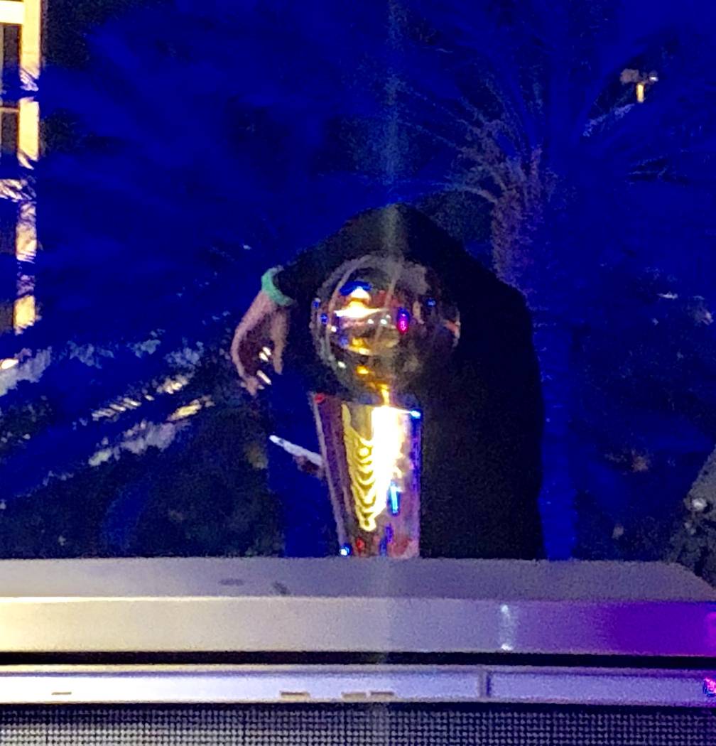 An unidentified individual leans on the Larry O'Brien NBA Championship Trophy at XS Nightclub a ...