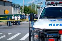 New York City Police officials gather along Wilcox Street behind the 121st Precinct station hou ...