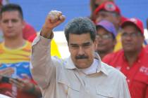 FILE - In this April 6, 2019 file photo, Venezuela's President Nicolas Maduro raises his fist t ...