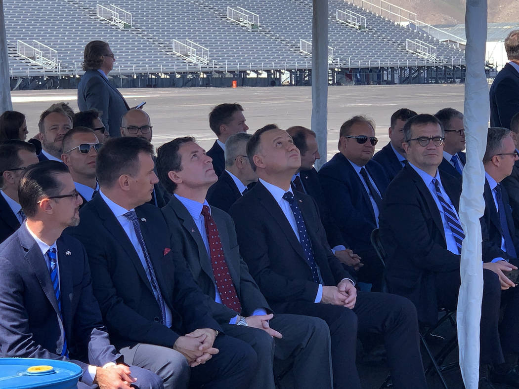 President of Poland Andrzej Duda and others look skyward at a drone flying above them at the Re ...