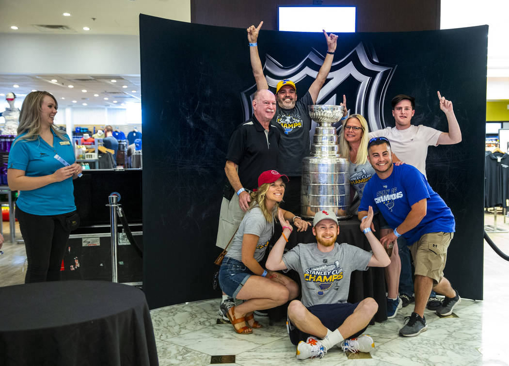 St. Louis Blues fans from the city pose about the Stanley Cup, the most recognizable and revere ...