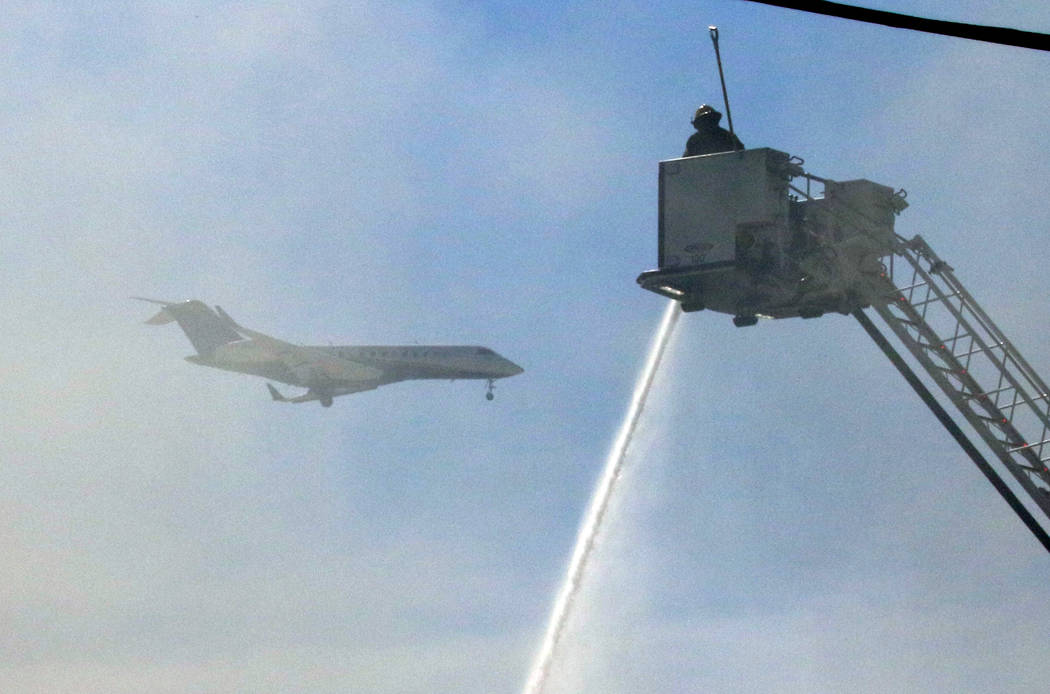 An airplane flies over East Flamingo Road and Twain as Clark County Fire Department and Las Veg ...