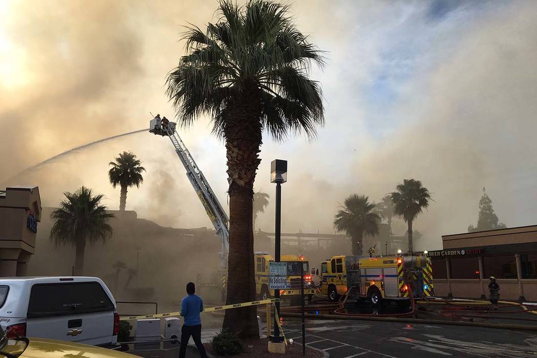 Heavy smoke from a fire surrounds a business complex near Paradise Road and East Twain Avenue i ...