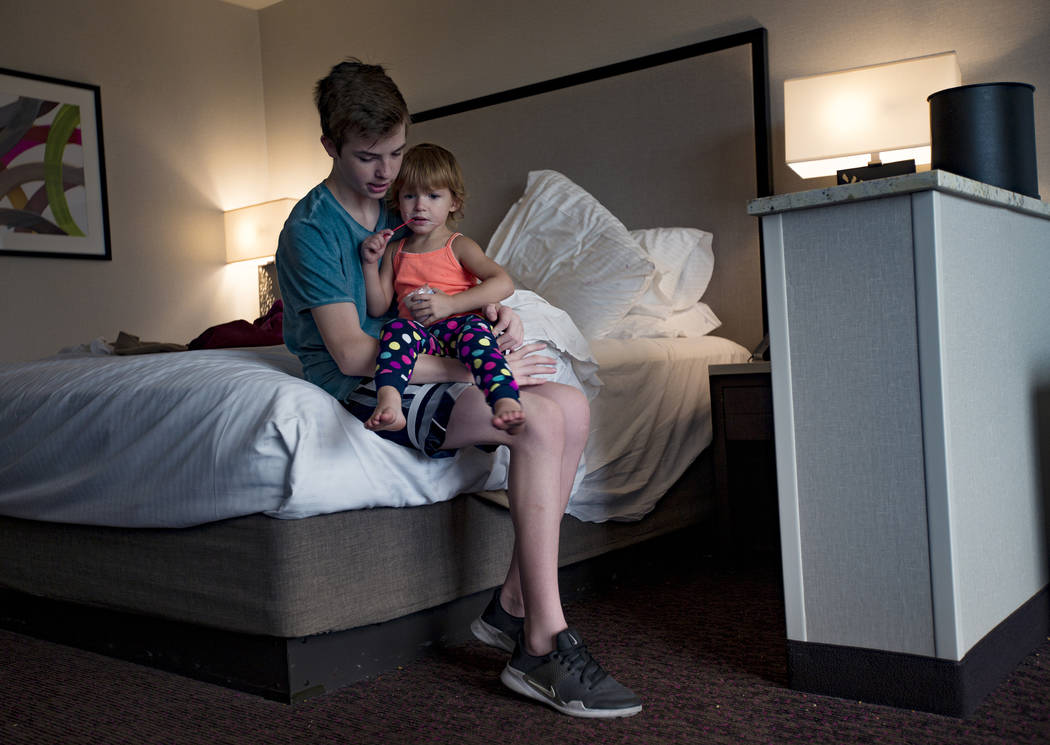 Westin Monson, 12, holds his sister Dixie Baalman, 2, at their family's hotel room at the Sunco ...