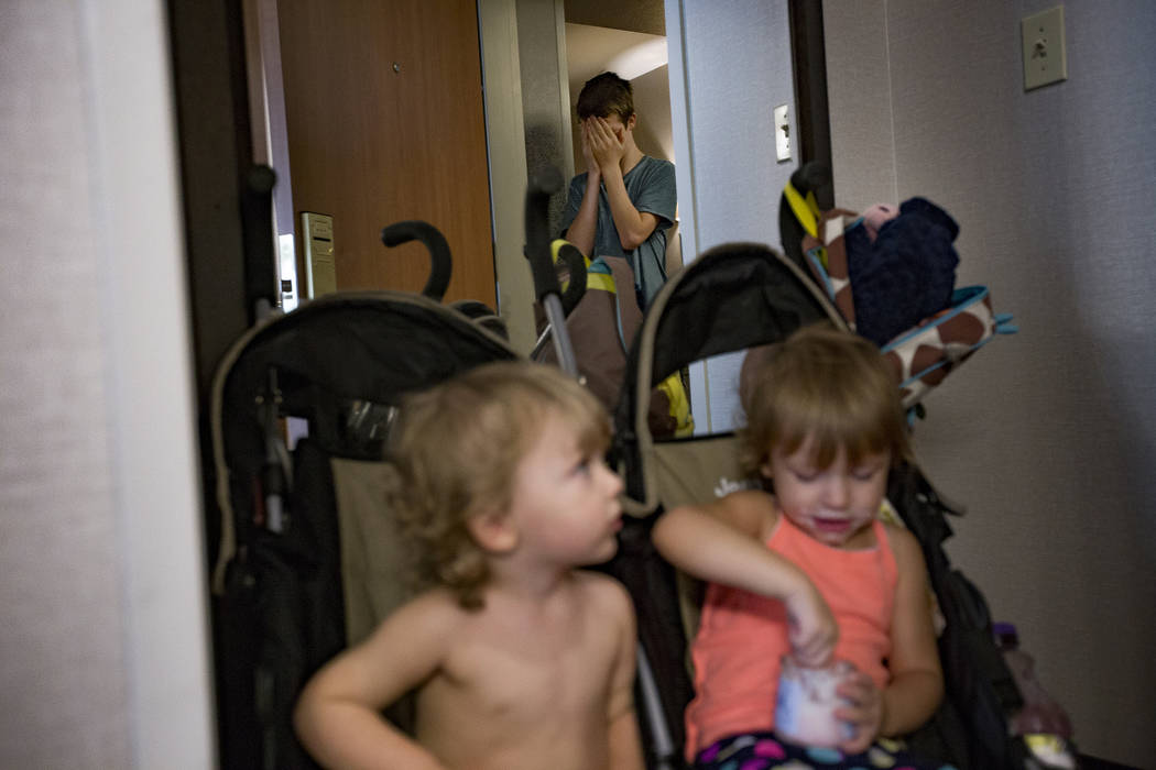 Davey Baalman, 1, and Dixie Baalman, 2, play hide-and-seek with their brother Westin Monson, 12 ...