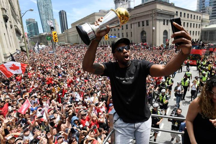 Toronto Raptors forward Kawhi Leonard takes a selfie holding his playoffs MVP trophy during the ...