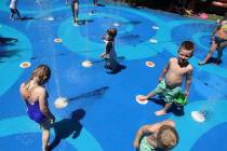 Children play at a splash pad at The District in Henderson on Friday, June 12, 2019. (Bizuayehu ...