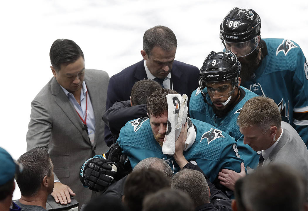 San Jose Sharks center Joe Pavelski, bottom center, is helped off the ice during the third peri ...
