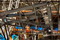 A crew in a lift examine a truss on the ground at Raiders Stadium where one of the 65-ton steel ...