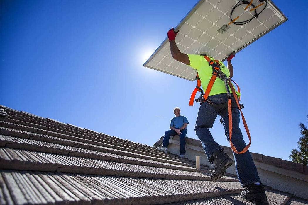 Matt Neifeld with Robco Electric carries a solar panel at a home in northwest Las Vegas on Frid ...