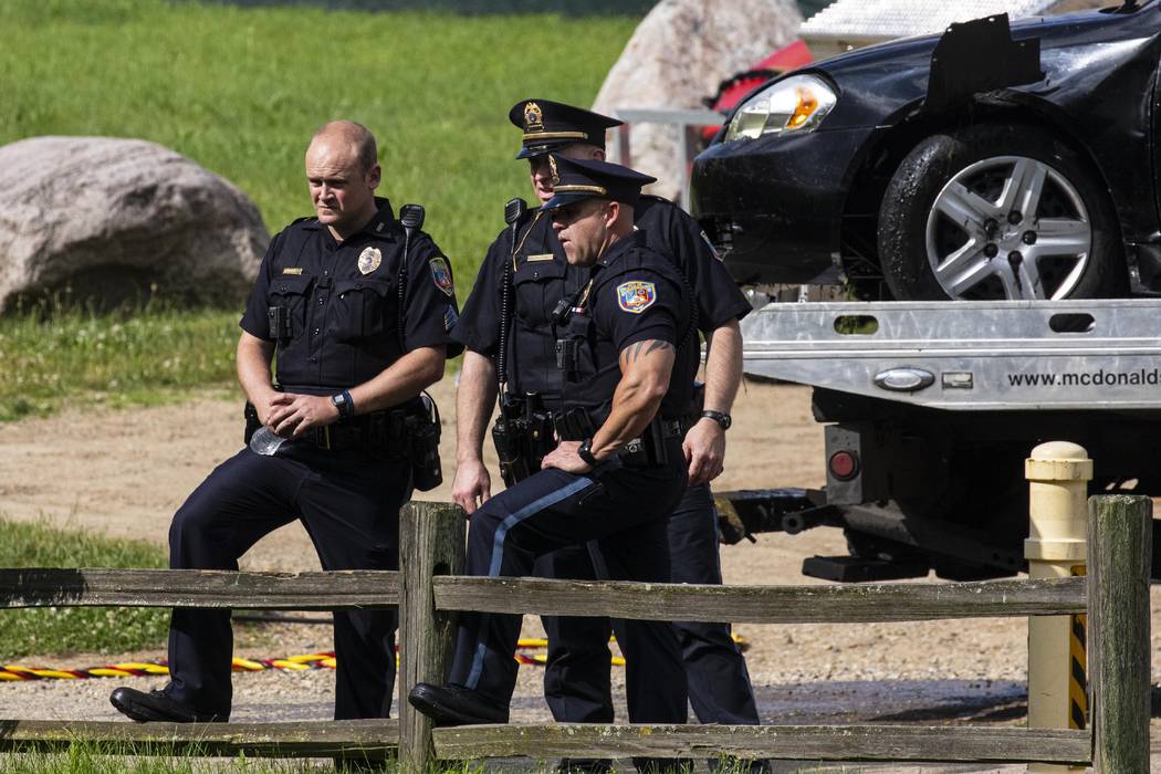 Police remove a black sedan from the Kalamazoo River near Verburg Park, Tuesday, June 18, 2019, ...