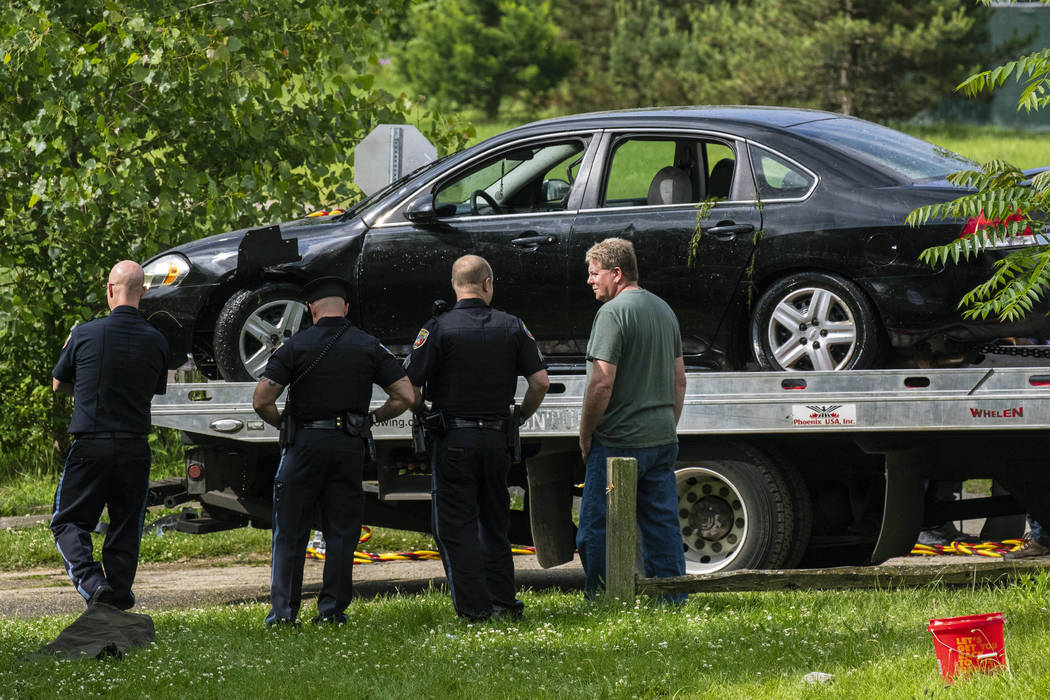 Police remove a black sedan from the Kalamazoo River near Verburg Park, Tuesday morning, June 1 ...
