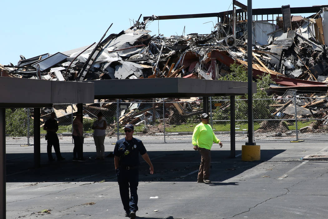 A Clark County firefighter walks past the rubble of burned-out office building at The Park at 3 ...