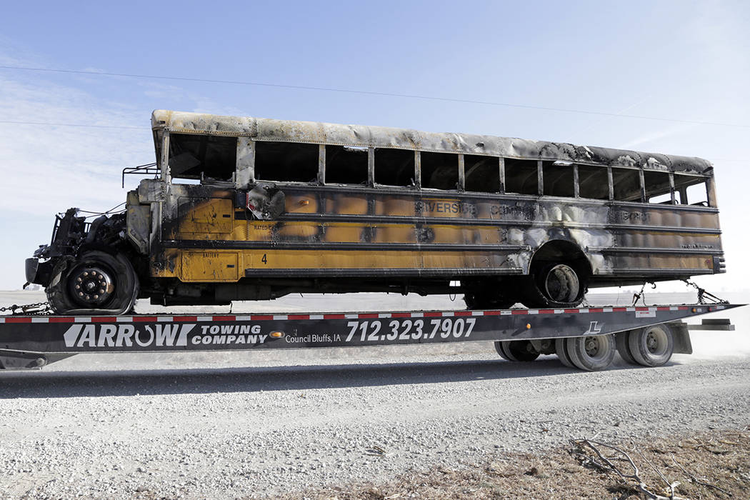 A burned school bus is transported by trailer near Oakland, Iowa, Tuesday, Dec. 12, 2017. A fir ...
