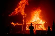FILE - In this Nov. 8, 2018 file photo, a home burns as a wildfire called Camp Fire rages throu ...