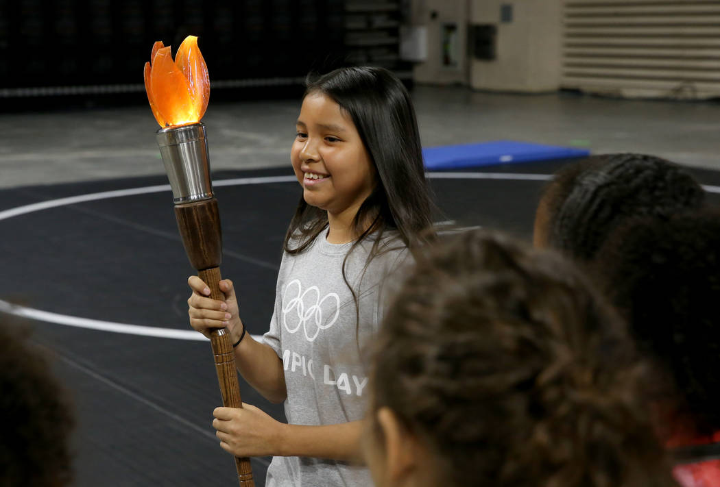 Destiny Chee, 11, carries the torch on Olympic Day at The Orleans in Las Vegas Tuesday, June 18 ...