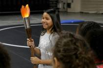 Destiny Chee, 11, carries the torch on Olympic Day at The Orleans in Las Vegas Tuesday, June 18 ...