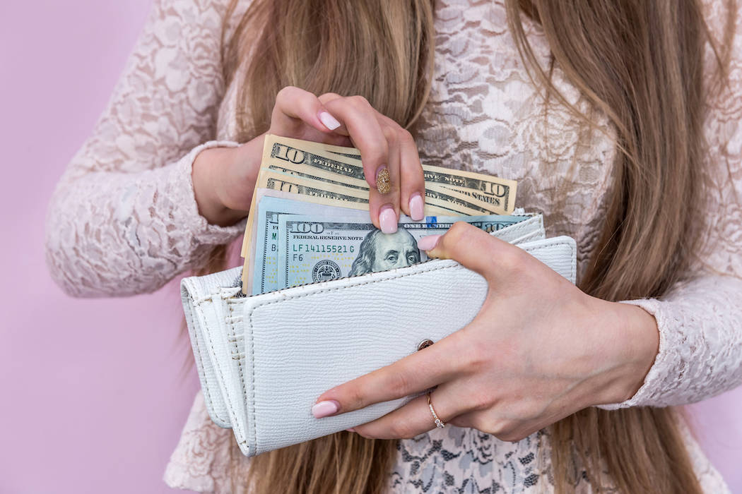 A woman holds a wallet (Getty Images)
