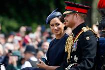 Britain's Meghan, the Duchess of Sussex and Prince Harry ride in a carriage to attend the annua ...