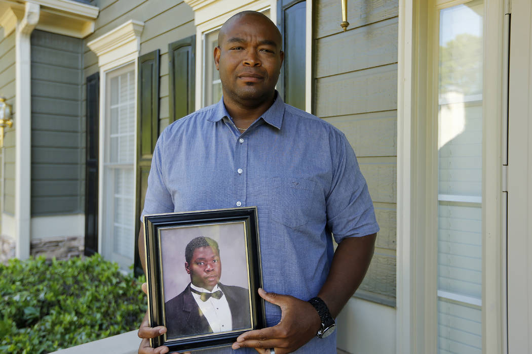 In this Friday, June 14, 2019 photo, Chris Parks poses with a portrait of his brother Donovan C ...