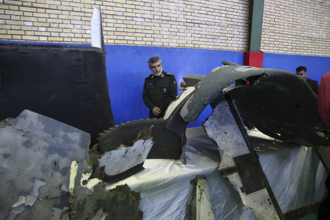 Head of the Revolutionary Guard's aerospace division Gen. Amir Ali Hajizadeh looks at debris fr ...